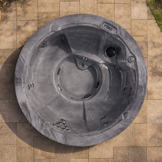 Top view of a gray hot tub on a tiled patio