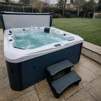 Hot tub on a patio with grass and trees in the background