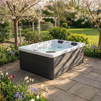 Hot tub in a garden setting with flowers and trees