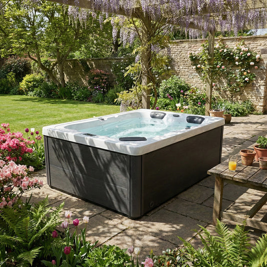 Hot tub in a garden setting with flowers and a table