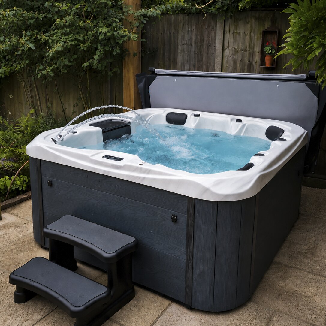 Retreat Plus hot tub with water and steps in a garrden setting
