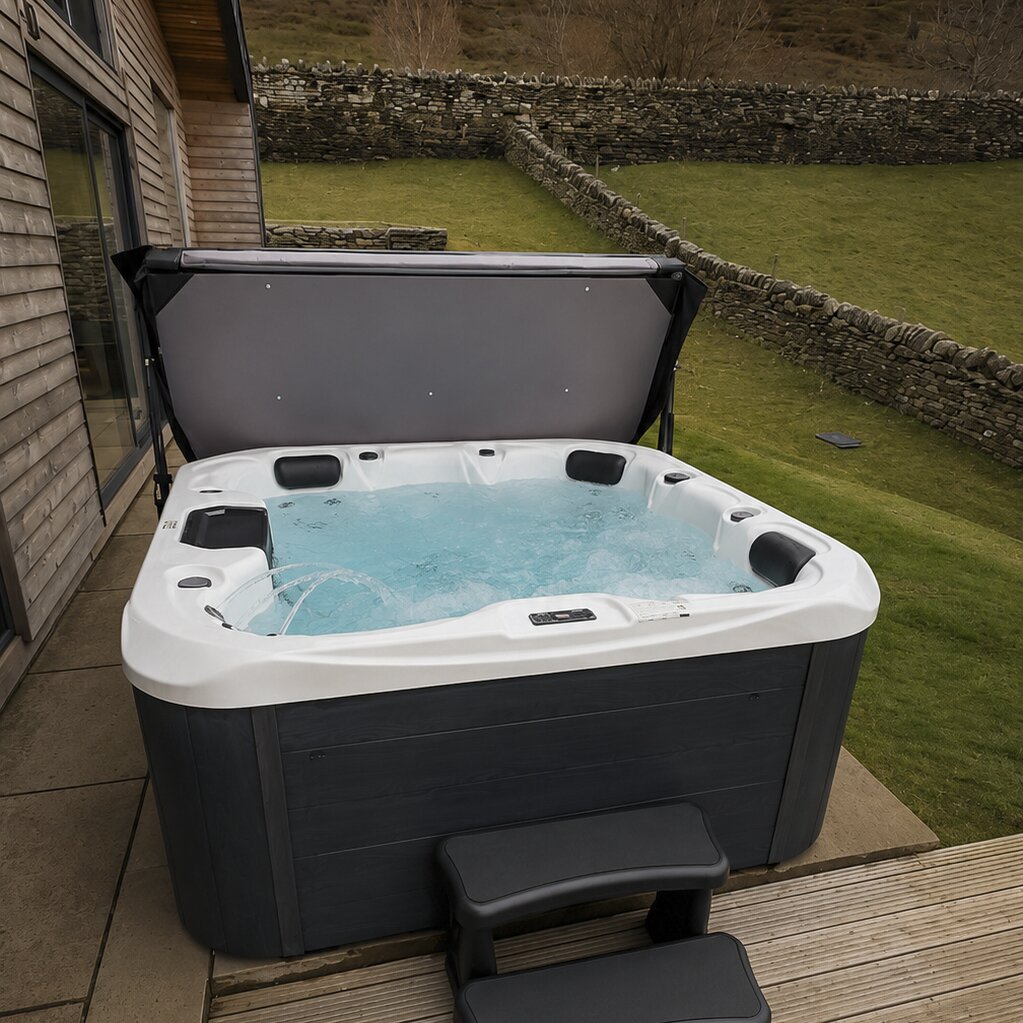 Hot tub on a wooden deck with a garden and stone wall in the background