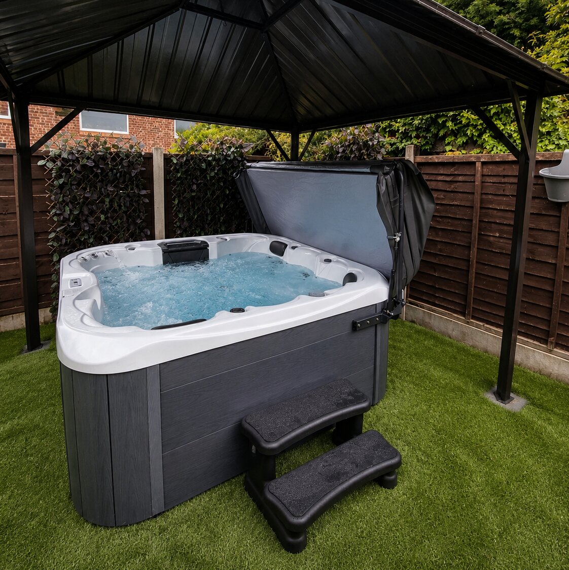 Hot tub with a black cover on grass under a wooden gazebo