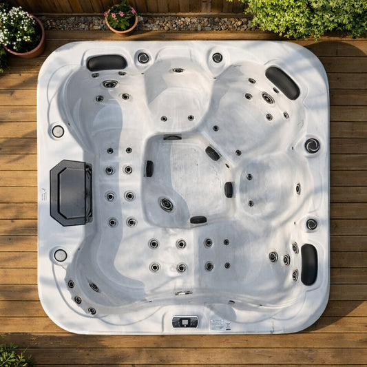 Top-down view of a hot tub on a wooden deck with plants around